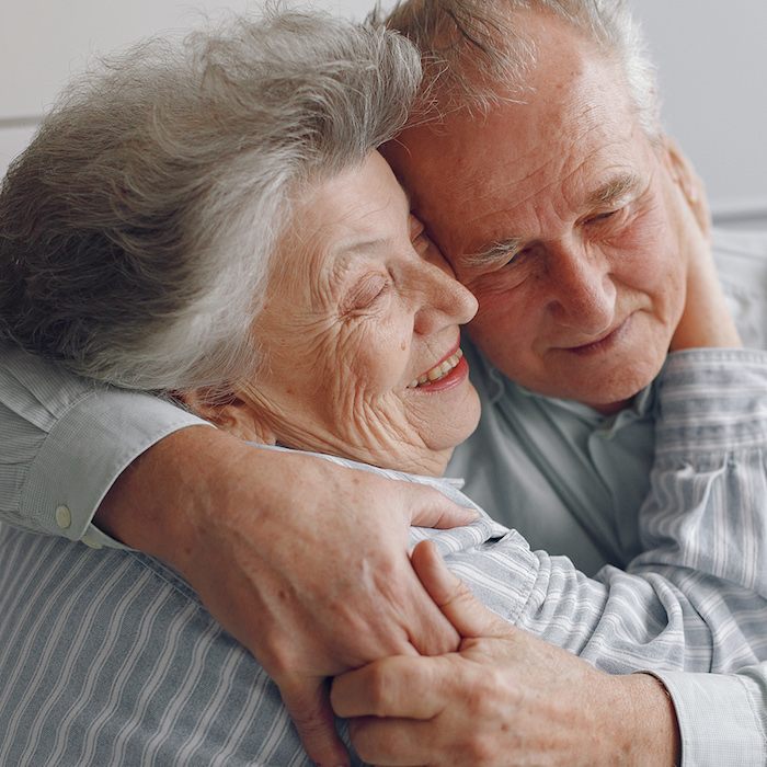 Image of two elderly people embracing.