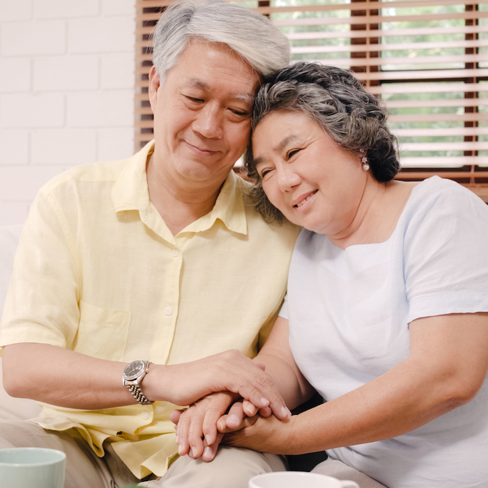 Image of an elderly couple leaning on each other.