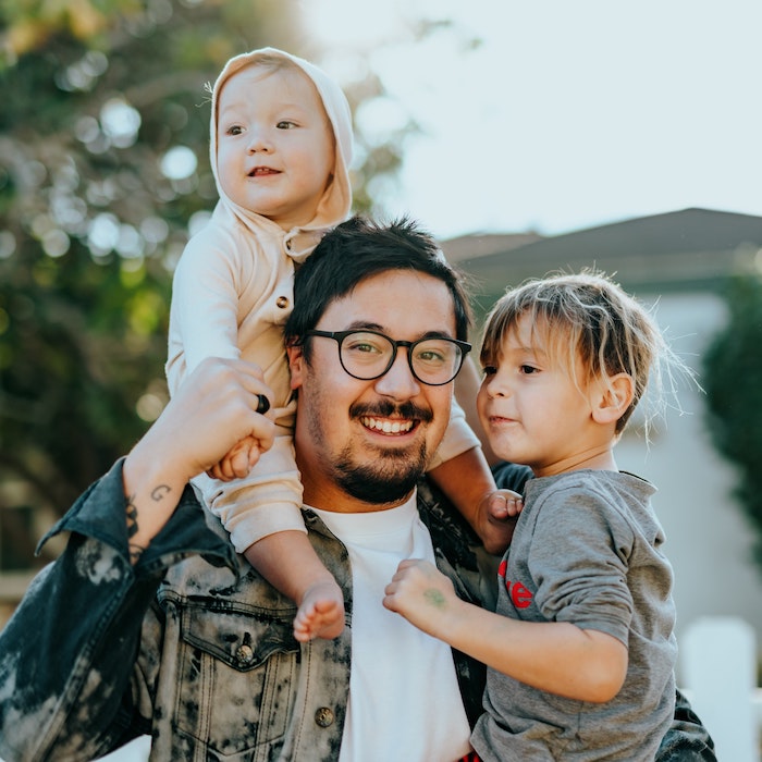 Image of a man holding his two kids.