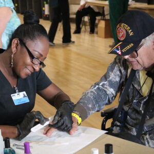 A nail technicians files the nails of a veteran.