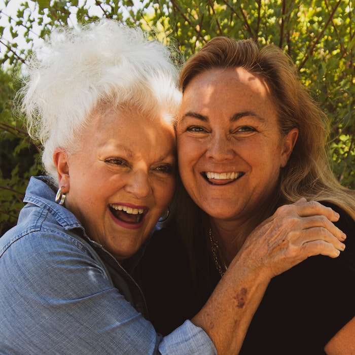 Image of two people embracing and smiling at the camera.